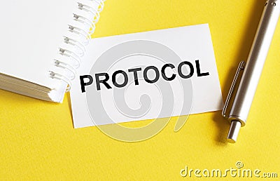 White paper with text PROTOCOL on a yellow background with stationery Stock Photo