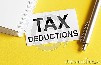 White paper with text Tax Deductions on a yellow background with stationery Stock Photo