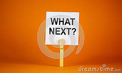 White paper with text `Whats next`, clip on wood clothespin. Beautiful orange background. Business concept. Copy space Stock Photo