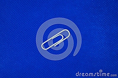 A white paperclip with a blue background Stock Photo