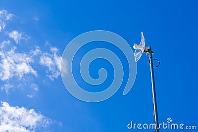 White parabolic grid antenna for home on blue sky Stock Photo