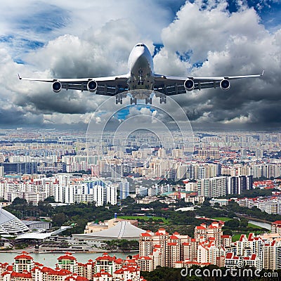 Passenger plane flies above the center of the big city. Front view of aircraft Stock Photo