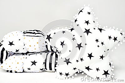 White patchwork feather comforter with black and gold stars and black stripes and white star shaped soft pillow with black s Stock Photo