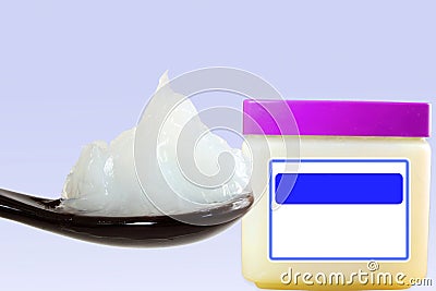 White petroleum jelly in spoon with jar in sky blue background Stock Photo