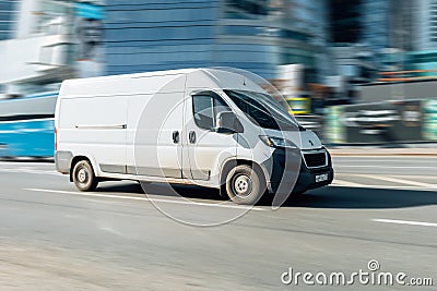 White Peugeot Boxer panel van in fast motion on city street. Fast moving cargo car on urban road Editorial Stock Photo