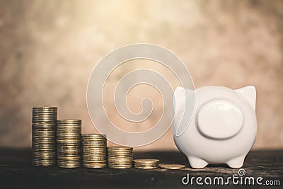 White piggy bank and coin on wood Stock Photo