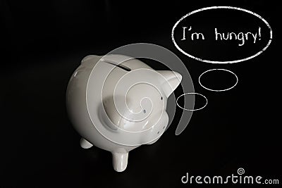 Piggy bank with thought bubbles, thinking I m hungry Stock Photo