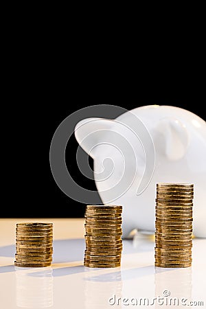 White piggy bank with stack of coins Stock Photo