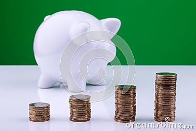 White piggy bank with stack of coins Stock Photo