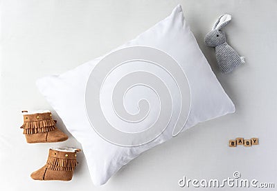 White Pillow With Baby Shoes and Toy Props Mockup - Styled Stock Photography Stock Photo