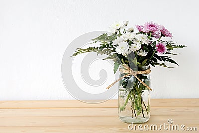 White and pink daisy bouquet in mason jar on table background Stock Photo