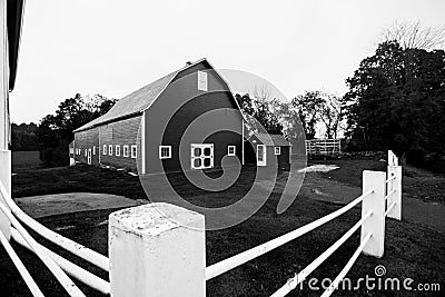 White pipe fence and American traditional barn. Stock Photo