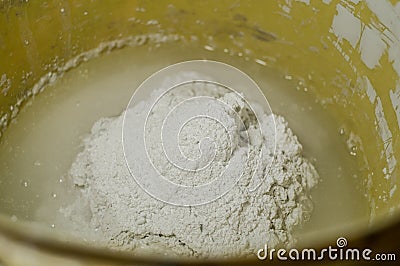 White plaster in a bucket of water. Preparation of mixture for finishing walls and ceilings in the apartment. Repair in Stock Photo