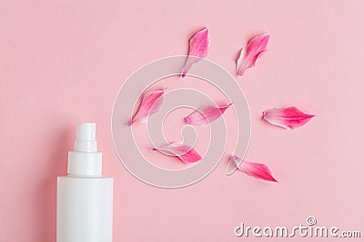 White plastic bottle of floral facial moisturizing toner or rose hair spray and petals isolated on pastel pink background Stock Photo