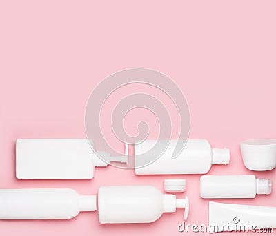 White plastic cans on a pink background. Cosmetics for skin care. Means for washing, disinfecting and washing Stock Photo