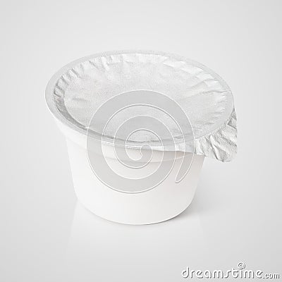 White plastic container with foil lid on gray Stock Photo