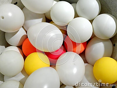 White plastic eggs and balls of different color laying together Stock Photo