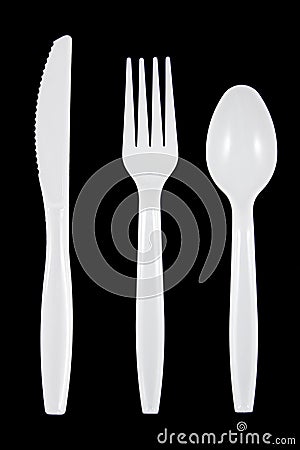 White plastic knife, fork and spoon on black background. Stock Photo