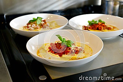 White plate with colorful italian pasta Bolognese, creamy yellow sauce and green basil. Stock Photo