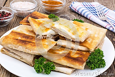 White plate with envelopes of thin Armenian bread lavash fried Stock Photo