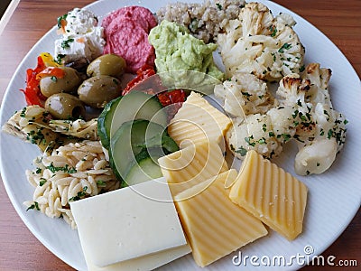 A plate filled with a variety of cheese and Cold salads Stock Photo