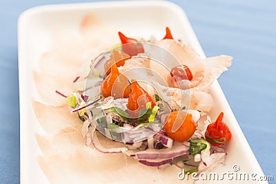 White plate with white fish sashimi, purple onion, red pepper and chives Stock Photo