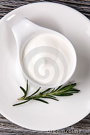 White plate full of sour cream on wooden table Stock Photo