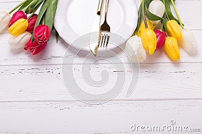 White plate, golden cutlery and white and red tulips flowers on Stock Photo