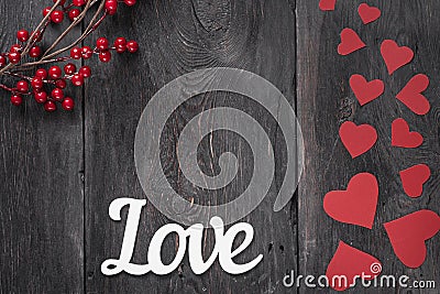 The word Love on a rustic background with red cardboard hearts on the side as a symbol of Valentine`s Day Stock Photo