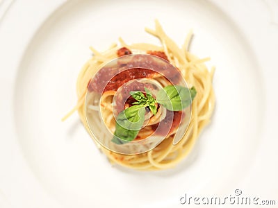 White plate, spaghetti top view, with red tomato sauce and green basil leaves on top Stock Photo