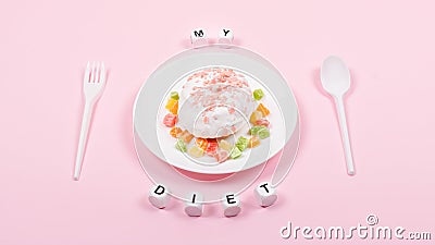 White plate with spoon, fork and Donut decorated icing and sprinkles. Unhealthy Junk Food. Dieting, Healthy Eating, Lifestyle. Stock Photo