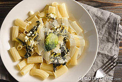 1 white plate with tortilloni with sauce and spinach and cheese, broccoli, fork, napkin on a light background, spinach paste Stock Photo