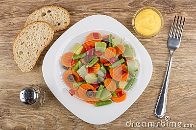 White plate with vegetable mix, bowl with sauce, bread, pepper Stock Photo