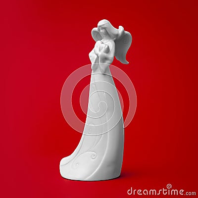 White porcelain angel sculpture with heart in hands Stock Photo