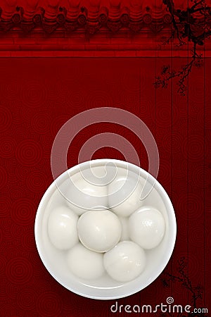 A white porcelain bowl of rice balls is placed on a traditional auspicious cloud, plum, and wooden board texture background. Stock Photo