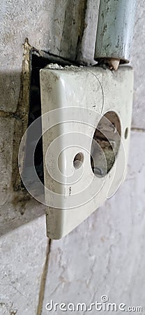 The white power outlet box on the wall is starting to open because it`s been old. Stock Photo