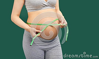 Pregnant woman measuring stomach with measuring tape Stock Photo