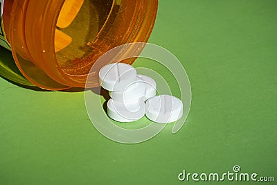 White prescription pills spilled onto a table. Concept of opioid addiction Stock Photo