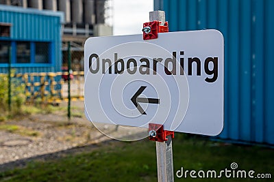 Sign `Onboarding` with arrow to the left side with undefined industrial background Stock Photo