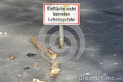 White red edged sign in a frozen lake with black inscription: 