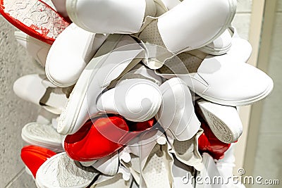 White and red shoes hung on the shop window Stock Photo