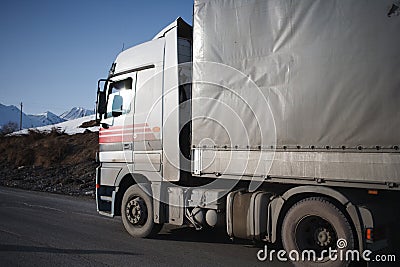 White refrigerated truck on winter road on background of the mountains Stock Photo