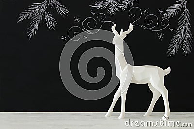 White reindeer on wooden table over chalkboard background whith hand drawn chalk illustrations. Cartoon Illustration