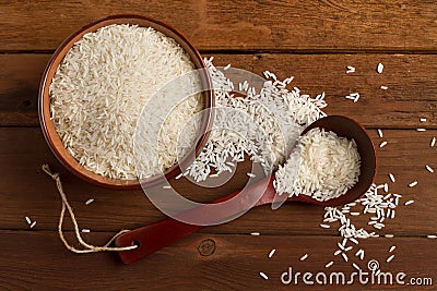 White rice in a ceramic bowl and spoon on a wooden table Stock Photo