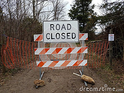 White road closed sign and striped barricade with trail or path Stock Photo