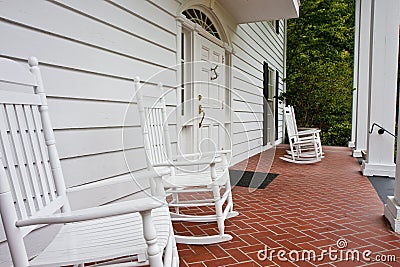 White Rockers on Red Tile Porch Stock Photo