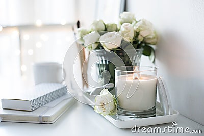 White room interior decor with burning hand-made candle and bouq Stock Photo