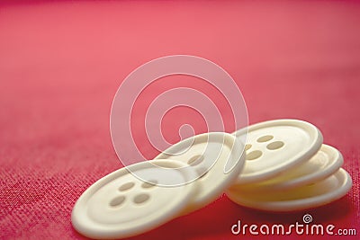 White round buttons in the form of slides lie on the red surface close-up Stock Photo