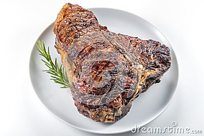 White round plate with Whole grilled T-bone steak and rosemary Stock Photo