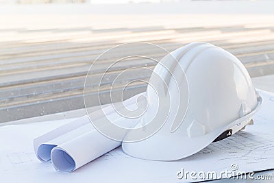 The white safety helmet put on the blueprint at construction site Stock Photo